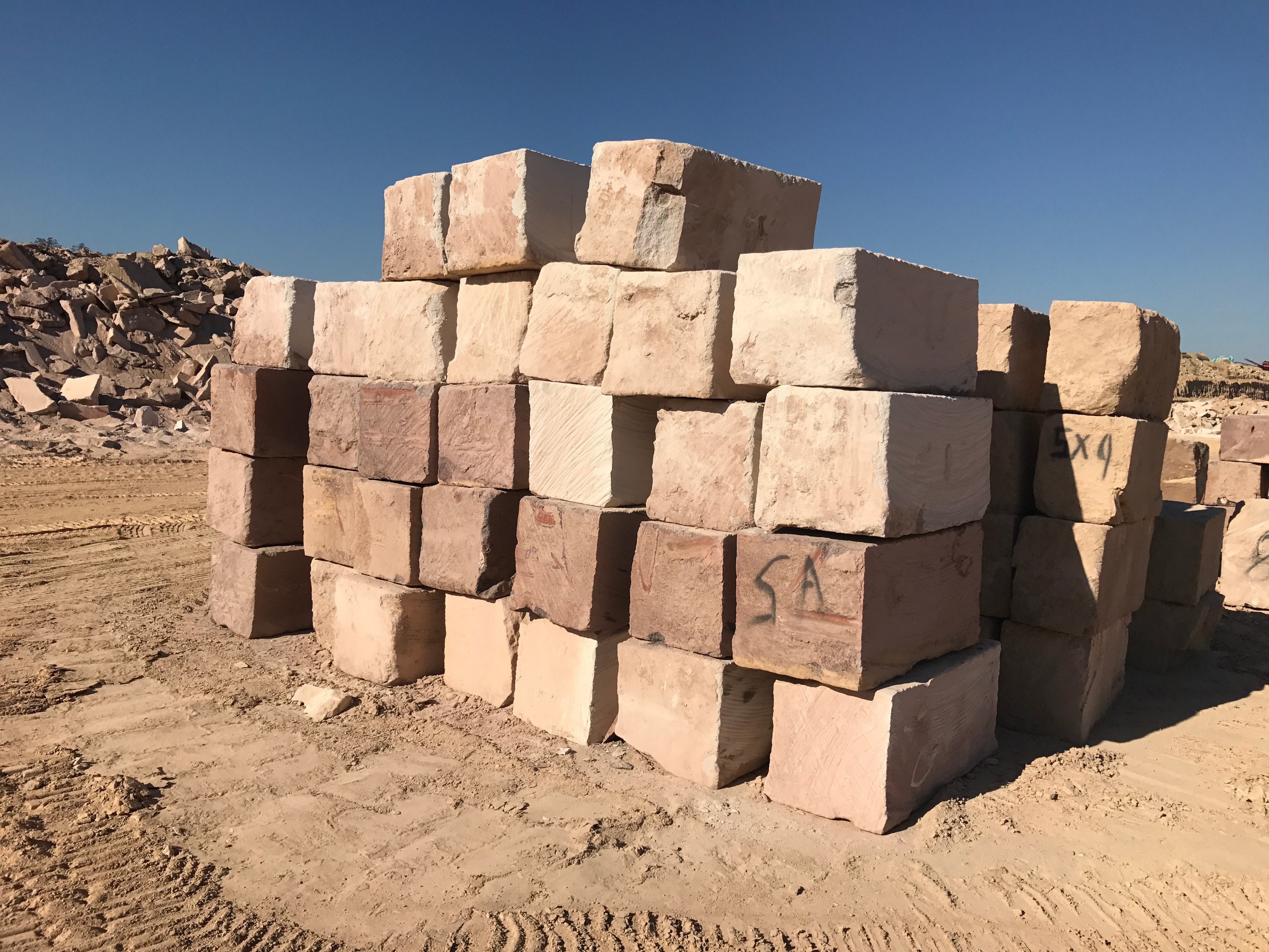 Stacked pink and cream sandstone blocks at quarry