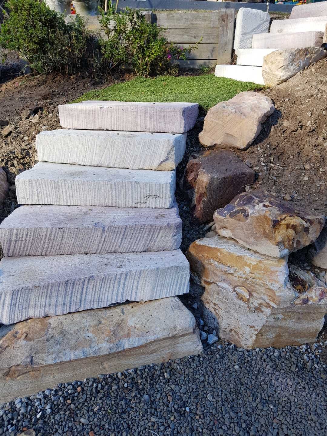 Sandstone slab steps with boulder edging and artificial turf garden